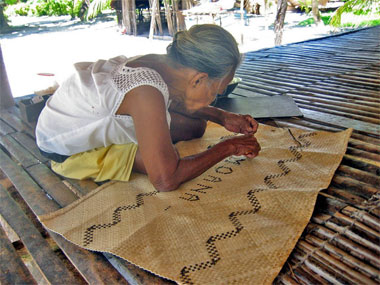Mangura's mother making the mat